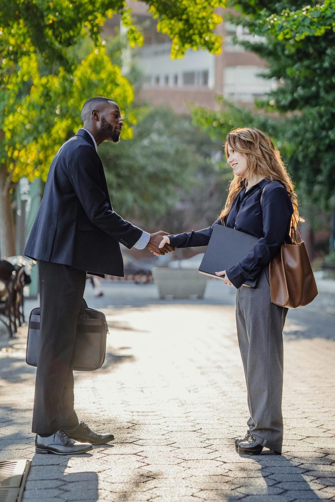 How Skilled Property Mediators Help Avoid Courtroom Battles, a man and a women in offcie attire shaking hands outside.jpg